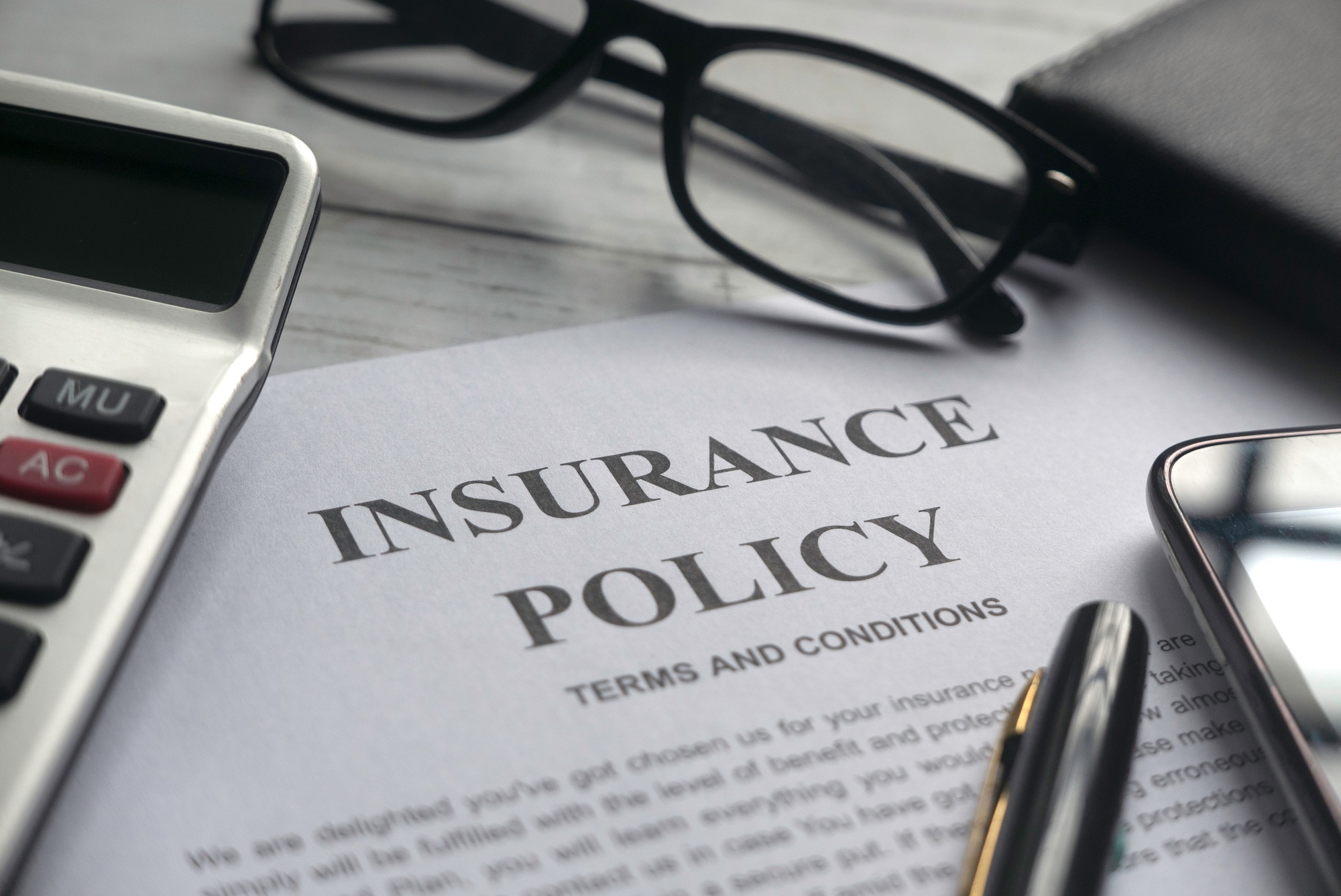 Homeowners insurance policy document with pen